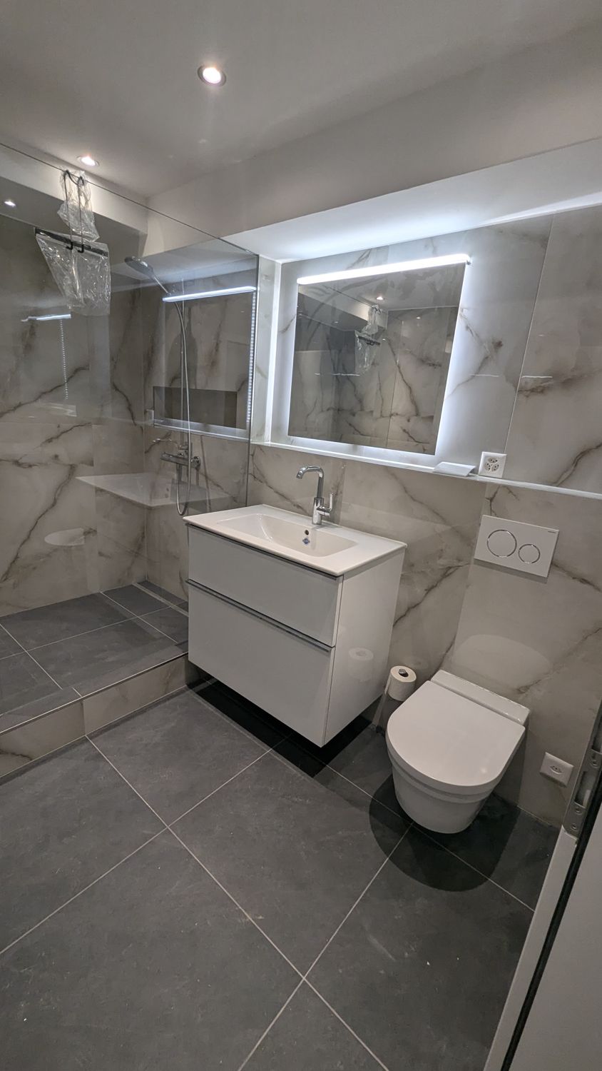 Graues Bad mit Marmoroptik, Dusche und Lavabo