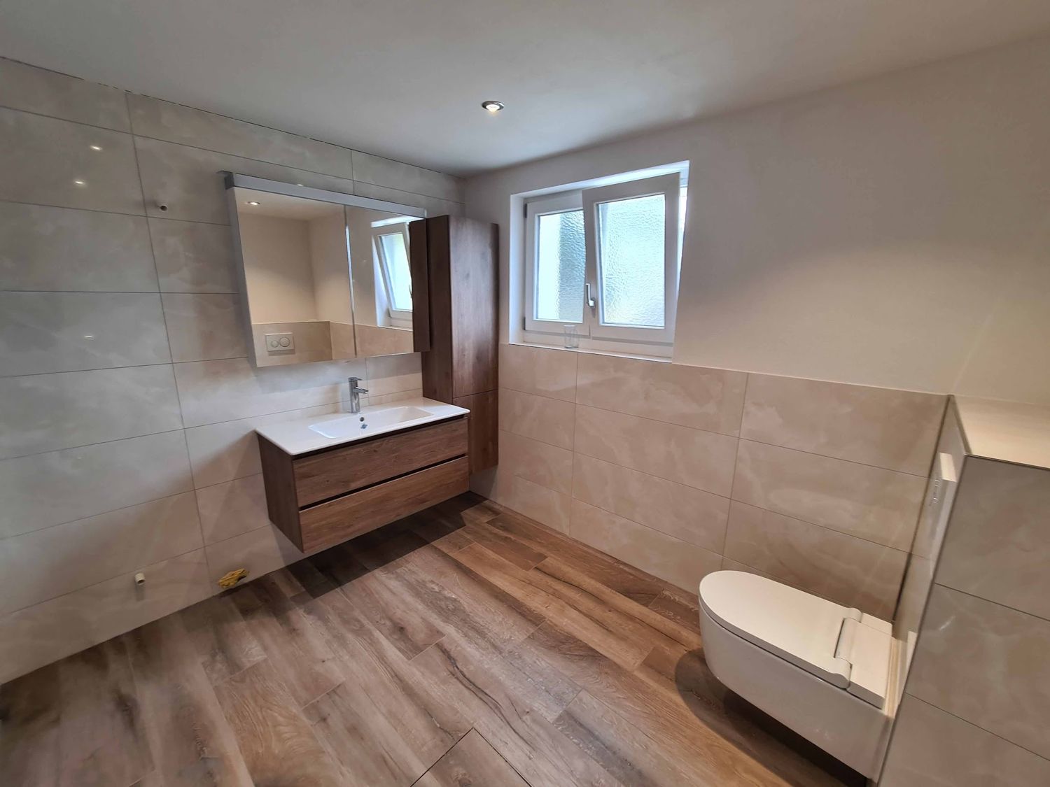 Bad mit Holzoptik-Boden und Wandschrank